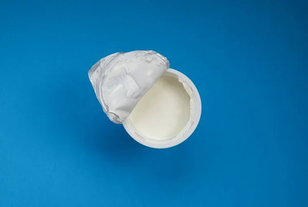 Frasco abierto con crema agria o yogur con tapa de aluminio . — Foto de Stock