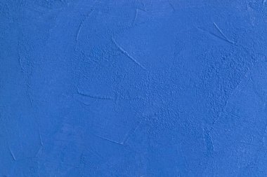 Yüzeyin yakın çekimi alçı dokusuyla parlak mavi renktedir. Yatay yönelim, seçici odaklanma. Klasik mavi..