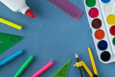 Mavi yüzeydeki okul için birkaç kırtasiye malzemesi.