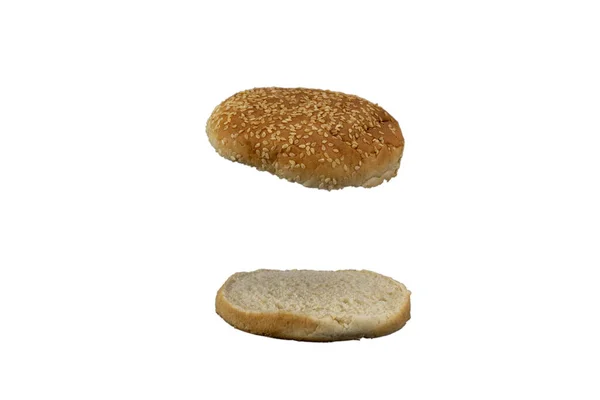 Hamburgerin üstü ve altı beyaz arka planda susamlı.