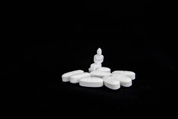 Siyah arka planda hasta bir kadınla beyaz haplar.