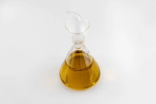 Beyaz arka planda ekstra bakire yağı olan cam yağ kutusu.