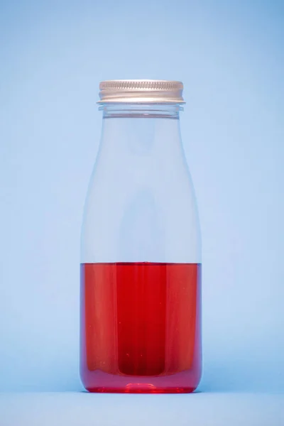 Bebida Roja Una Olla Transparente Con Fondo Azul —  Fotos de Stock