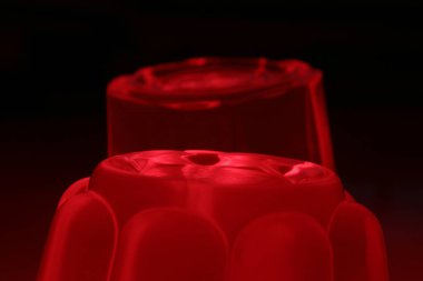 Siyah arka planda iki porsiyon kırmızı jelatin.