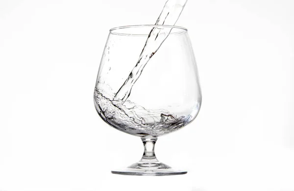 Onları beyaz arka planda suyla dolduran bir fincan.