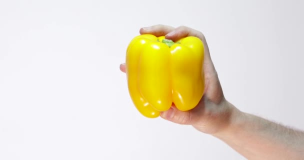 Gelber Pfeffer Mit Einer Hand Vordergrund Vor Weißem Hintergrund — Stockvideo