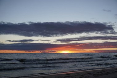 Günbatımı sahil kıyısında dalgaları ile