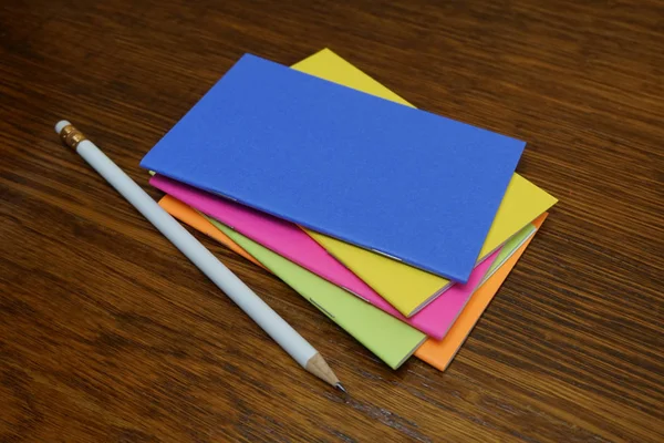 彩色笔记本在木桌用白色铅笔 — 图库照片