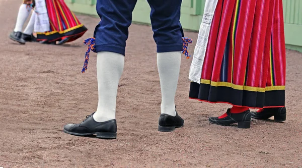 Legs of  man and woman in Estonian traditional suits