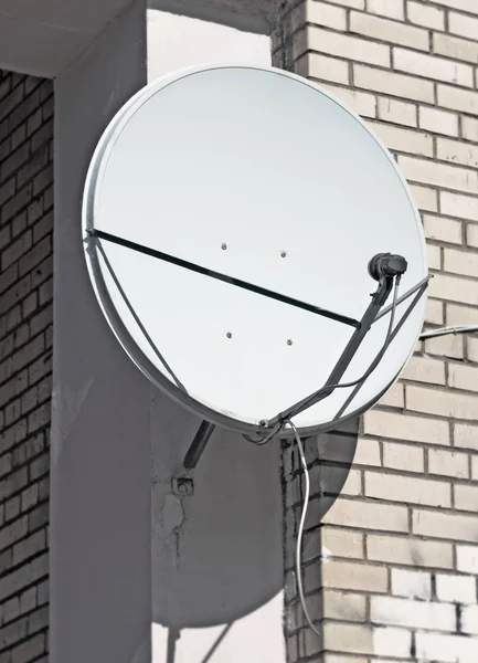 Спутниковая антенна на стене кирпичного здания — стоковое фото