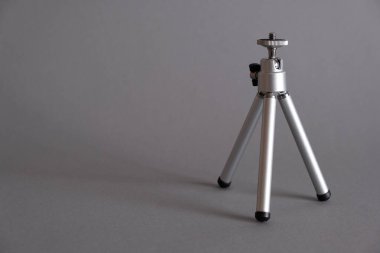 Gri arkaplanda alüminyum küçük tripod..
