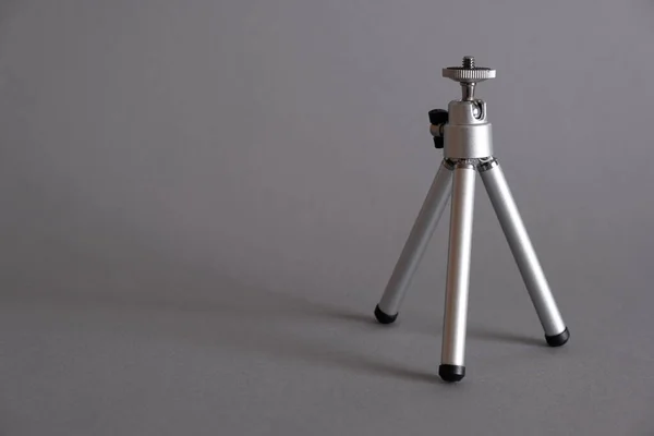 Gri arkaplanda alüminyum küçük tripod..