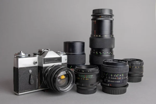 Eski model kamera ve gri BG 'de beş eski metal lens..