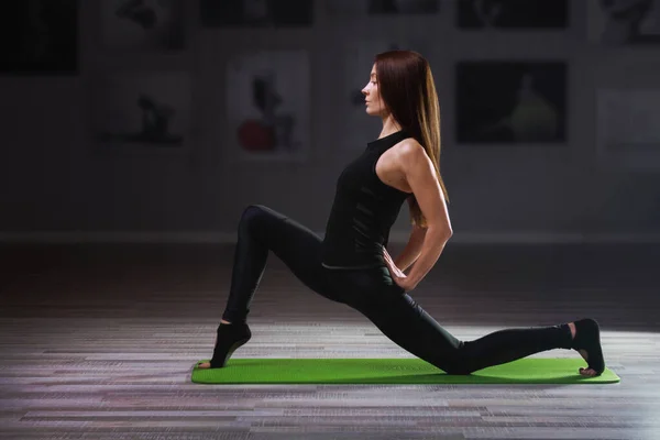 Jeune femme pratiquant le yoga sur tapis vert — Photo