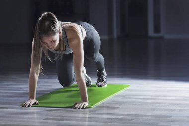 Women making plank pose in fitness studio