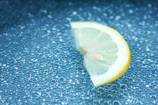 Agua burbujas frescas en agua mineral con fondo de limón —  Fotos de Stock