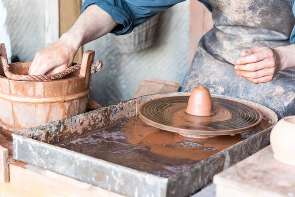 Man die pot op potter wiel in een workshop — Stockfoto