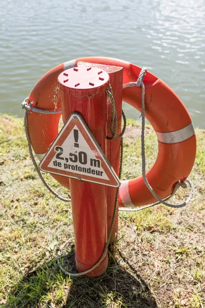 Boya salvavidas o boya de rescate flotando cerca del río para rescatar a la gente del hombre que se ahoga. Equipo de seguridad . — Foto de Stock