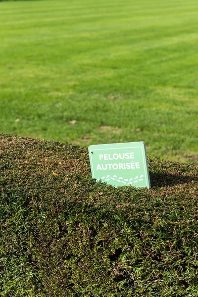 Sign in French lawn allowed, in a park