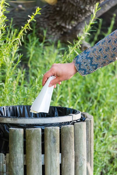 Wanita membuang kertas di tempat sampah kayu — Stok Foto