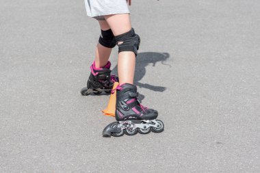 küçük kız sokakta Rollerblade yapıyor
