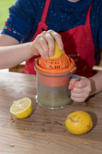 Little girl squeezing a lemon — Stock Photo, Image