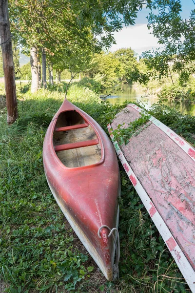 Canoa en la orilla, frente a un río — Foto de Stock