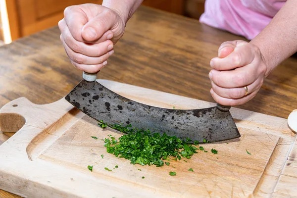 Woman chopping parsley in her kitchen — Stock Photo, Image