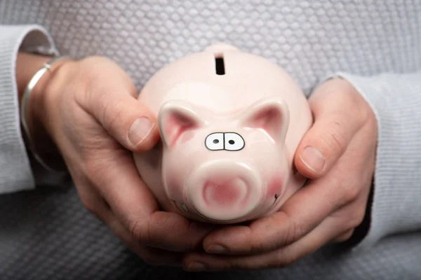 Woman holding in her hands a piggy bank — Stock Photo, Image