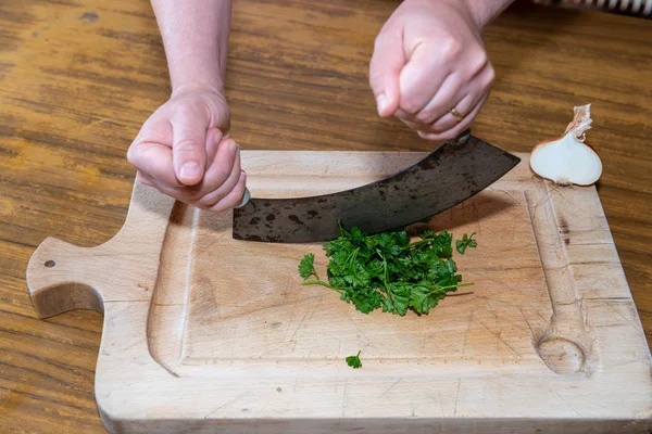 Wanita memotong peterseli di dapurnya — Stok Foto