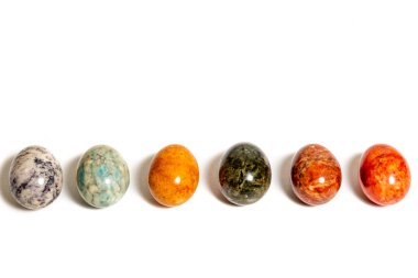 Beyaz arka planda doğal çok renkli taş yumurtalar.