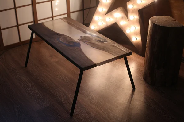 Wood and epoxy table with star lamp in wooden interior — Stock Photo, Image