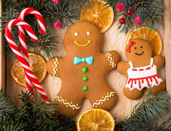 Gingerbreads 夫妇圣诞节自制的姜饼饼干在木桌上 姜饼人 蜜饯水果 传统的圣诞款待 — 图库照片