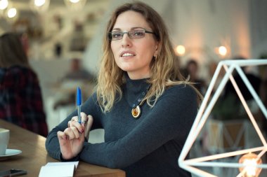 Bir kadın onun not defterinde notlar yapıyor.