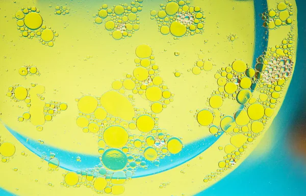 Lingkaran Minyak Pada Latar Belakang Air Kuning Latar Belakang Abstrak — Stok Foto