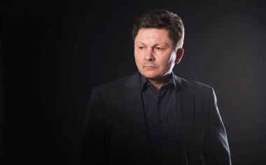 Karanlık bir arka plan üzerinde bir orta yaşlı iş adamı portresi.