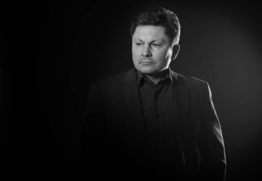 Siyah ve beyaz elbiseli bir iş adamı portresi. Orta yaşlı adam.