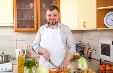 Yetişkin adam havuç keser. Akşam yemeği için taze sebze salata hazırlanıyor. Sağlıklı yaşam teşviki. Çok sağlık için faydalı olduğunu taze sebze yemek.