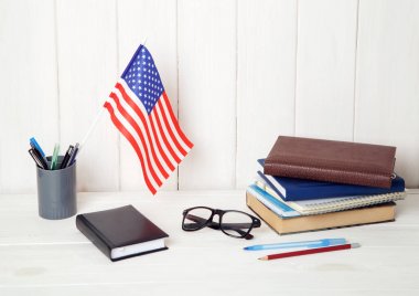 Kitaplar, egzersiz kitap, gözlük ve ABD ahşap bir masa üzerinde bayrak. İngilizce dil öğrenme. Eğitim Amerika Birleşik Devletleri.