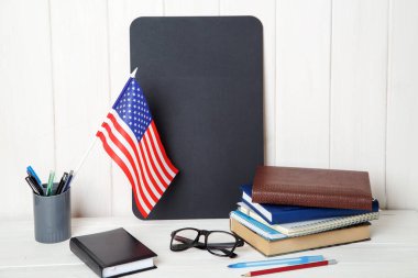 Kitap, defter, Not alanı ve ABD ahşap bir masa üzerinde bayrak. İngilizce dil öğrenme. Eğitim Amerika Birleşik Devletleri.