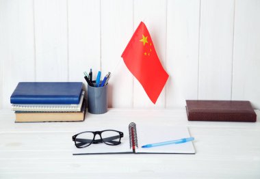 Kitap, defter, ders kitapları, gözlük, Chine bir bayrak üzerinde ahşap bir masa. Çin eğitim.