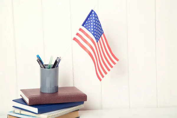 Books and the US flag on the desk. English language learning. Flag the United States of America.
