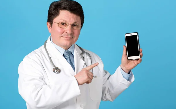 Call Doctor Middle Aged Doctor Pointing Phone Standing Blue Background — Stock Photo, Image