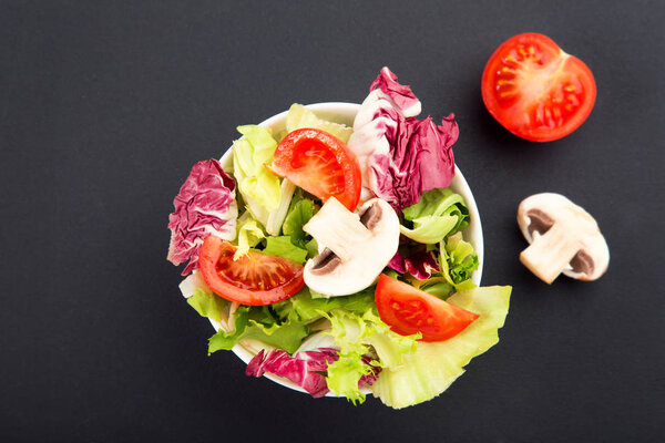 Plate with salad of fresh green leaves, tomato and mushroo
