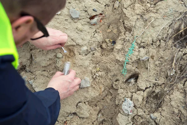 Adam ekolojist ihracat ve dökümü çöp ile kirlenmiş topraklarda toprak örnekleri alır.