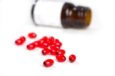 Kırmızı renk E vitamini Tablet ve şişe üzerinde beyaz bir arka plan.