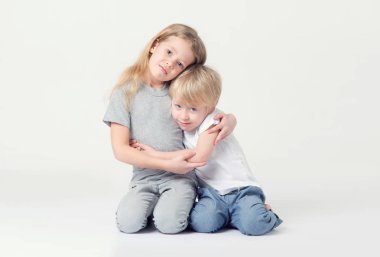 4 yaşında bir çocuk ve 6 yaşında bir kız sarılma oturuyor. Kız ve erkek kardeşim.