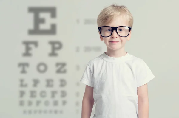 目のテストを持っている小さな男の子 ビジョンをテストするテーブル 医師の小児眼科医を訪問 — ストック写真