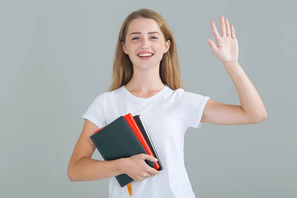 Hej Leende Kvinna Student Med Böcker Viftande Hand Står Ljusgrå — Stockfoto