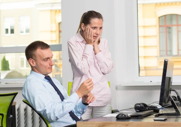 Surprise from the work of the employee and the leader. Business man and woman are surprised to discuss the result of working at a computer.